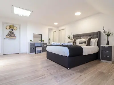 a bedroom with a large bed and a desk at Penthouse 23 in Newquay