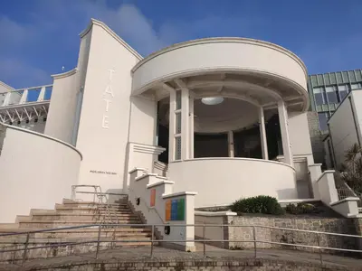a white building with stairs in front of a building at Cheerful Fisherman,s Cottage in St Ives