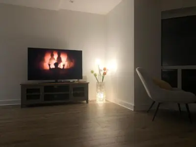 a living room with a television and a chair at The Towan Lookout in Newquay