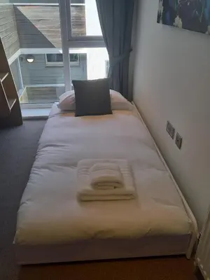 a large bed in a room with a window at The Towan Lookout in Newquay