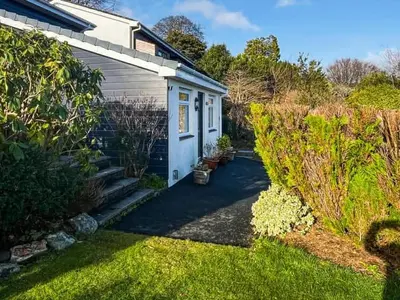 a small white house with a garden in the yard at Hillside in St Austell
