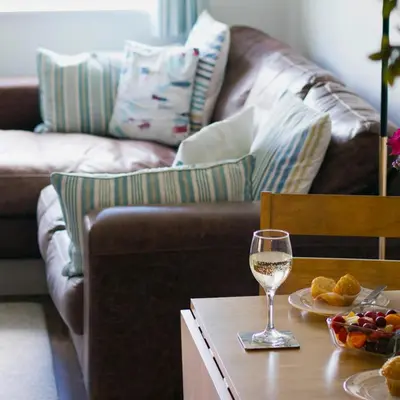 a glass of wine on a table with a couch at Hillside in St Austell