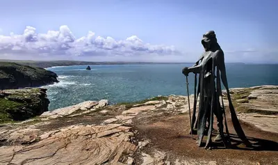 a statue of a man standing on a cliff near the ocean at Hillside in St Austell