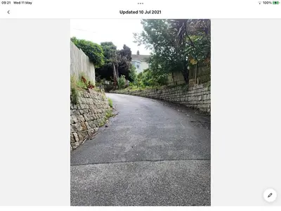 an empty road next to a stone wall at Bosloe in Helston