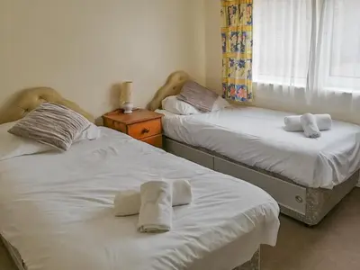 two beds in a bedroom with towels on them at Apartment 1 Waterrs Edge in Crantock