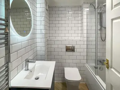 a white bathroom with a sink and a toilet at Apartment 1 Waterrs Edge in Crantock