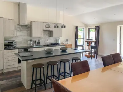 a kitchen with a large island with bar stools at The Hurlers in Saint Cleer