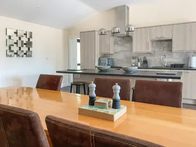a large kitchen with a wooden table and chairs at The Hurlers in Saint Cleer