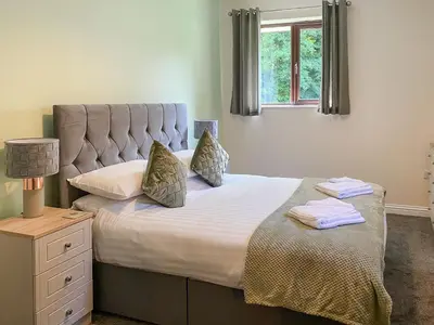 a bedroom with a large bed with a window at The Hurlers in Saint Cleer