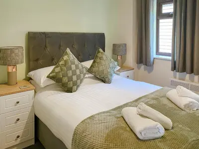 a bedroom with a bed with two towels on it at The Hurlers in Saint Cleer