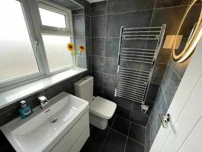 a bathroom with a sink and a toilet and a window at Island View - 3 Bedroom Holiday Cottage - 40m to Porthgwidden Beach - Sleeps 7 - inc FREE Parking in St Ives