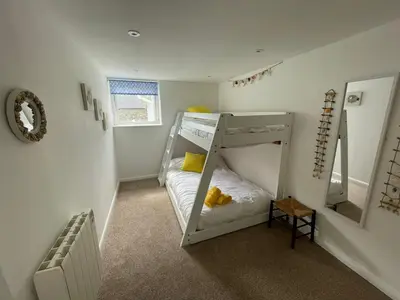 a bedroom with a bunk bed with yellow pillows at Island View - 3 Bedroom Holiday Cottage - 40m to Porthgwidden Beach - Sleeps 7 - inc FREE Parking in St Ives