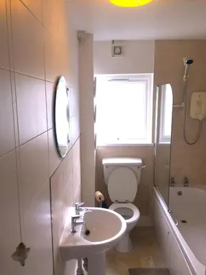 a bathroom with a sink and a toilet and a window at Island View - 3 Bedroom Holiday Cottage - 40m to Porthgwidden Beach - Sleeps 7 - inc FREE Parking in St Ives