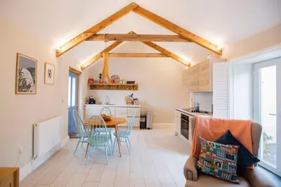 a kitchen and dining room with a table and chairs at Sleepers Barn in Saint Teath