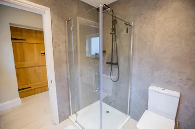 a bathroom with a shower with a toilet at Sleepers Barn in Saint Teath