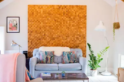 a living room with a blue couch and a brick wall at Sleepers Barn in Saint Teath