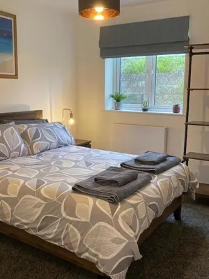 a bedroom with a bed with two towels on it at Saffron in Saint Columb Minor