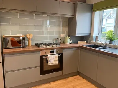 a kitchen with a stove top oven next to a sink at Saffron in Saint Columb Minor
