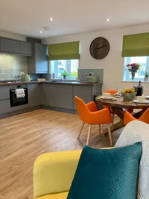 a kitchen and living room with a table and chairs at Saffron in Saint Columb Minor