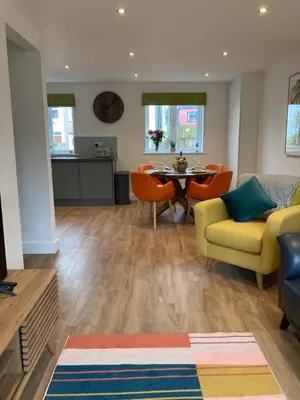 a living room with a yellow couch and a table at Saffron in Saint Columb Minor
