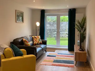a living room with a couch and a window at Saffron in Saint Columb Minor