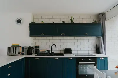 a kitchen with blue cabinets and a sink at Newquay Holiday Home in Newquay