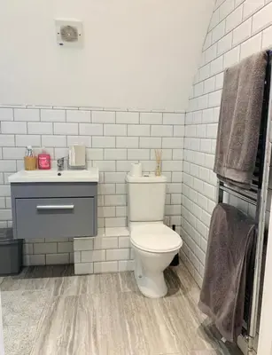 a white bathroom with a toilet and a sink at Romantic hideaway, seconds away from Perran beach in Perranporth