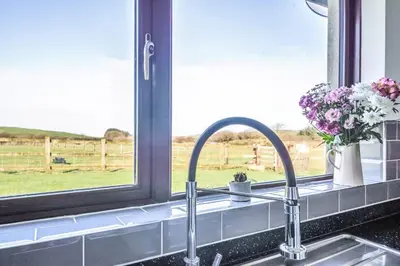 a kitchen counter with a sink and a window at Venn Down Lakes in Boscastle