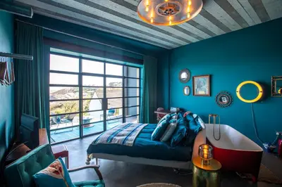 a bedroom with blue walls and a bed and a window at Chy conary in Carbis Bay