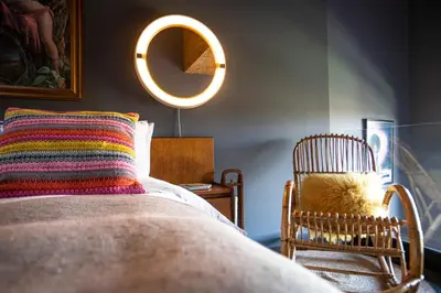 a bedroom with a bed and a chair and a mirror at Chy conary in Carbis Bay