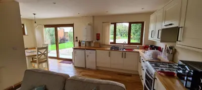 a kitchen with white cabinets and a counter top at Rockley Cottage, close to Eden project and Fowey. in Bodmin