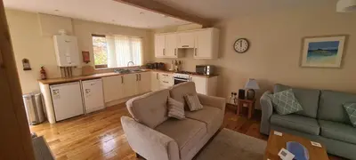 a living room with a couch and a kitchen at Rockley Cottage, close to Eden project and Fowey. in Bodmin