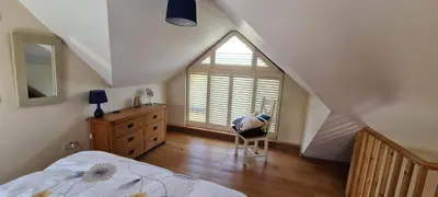 a bedroom with a bed and a large window at Rockley Cottage, close to Eden project and Fowey. in Bodmin
