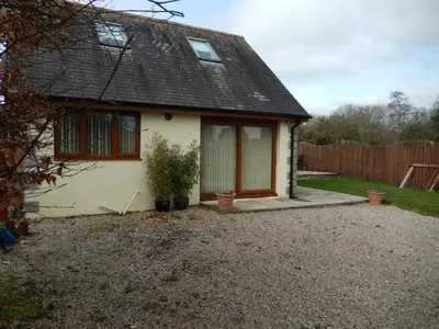 a house with a window and a fence at Rockley Cottage, close to Eden project and Fowey. in Bodmin