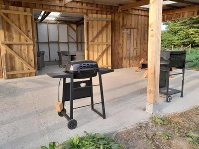 a grill and smoker on a patio in a barn at Cornish Skies Glamping in Pool