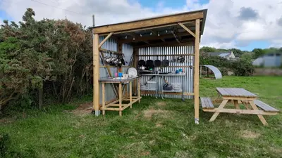 a small shed with a table and a picnic table at Cornish Skies Glamping in Pool