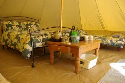 a room with a table with a bed and a table sidx sidx sidx at Cornish Skies Glamping in Pool