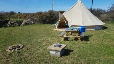 a tent with a picnic table in a field at Cornish Skies Glamping in Pool