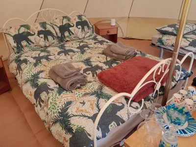 a hospital bed with a blanket and towels on it at Cornish Skies Glamping in Pool