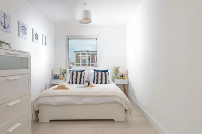 a white bedroom with a bed and a window at 45 Ocean 1, Newquay in Crantock