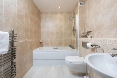 a bathroom with a tub and a toilet and a sink at 45 Ocean 1, Newquay in Crantock