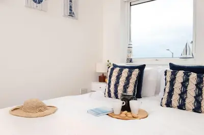 a bedroom with a bed with a hat and two pillows at 45 Ocean 1, Newquay in Crantock