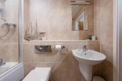 a bathroom with a sink and a toilet and a bath tub at 45 Ocean 1, Newquay in Crantock