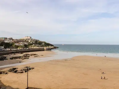 a beach with people on the sand and the ocean at 6 Ocean Heights in Newquay