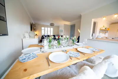 a dining room table with plates and vases on it at Trelowen in Padstow