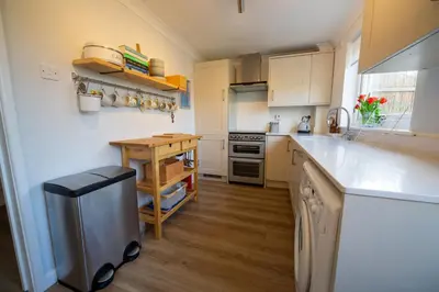 a kitchen with white cabinets and a counter top at Trelowen in Padstow