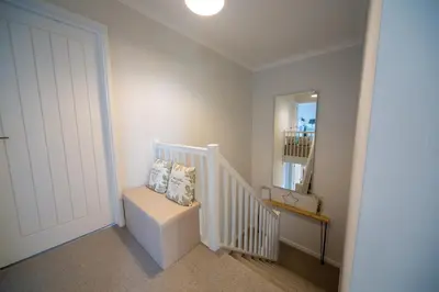 a white room with a staircase with a white door at Trelowen in Padstow