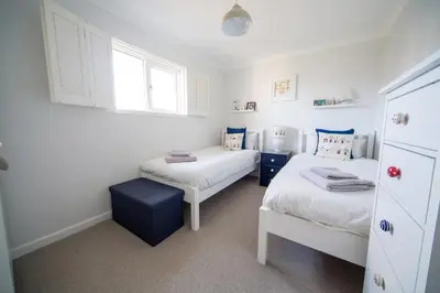 a bedroom with two twin beds and a window at Trelowen in Padstow