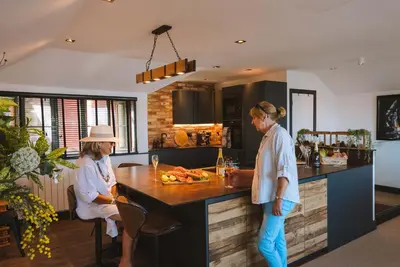 two women standing in a kitchen with a counter at Stunning Waterfront Apartment With Spectacular Views & Parking at 'CAPTAINS LOFT' in Falmouth