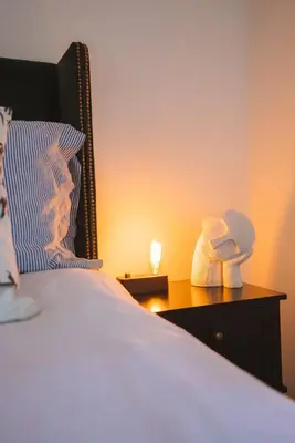 a bedroom with a bed and a night stand with a lamp at Stunning Waterfront Apartment With Spectacular Views & Parking at 'CAPTAINS LOFT' in Falmouth